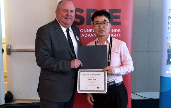 Yang, right, is presented with his award during the 2020 Photonics West conference.